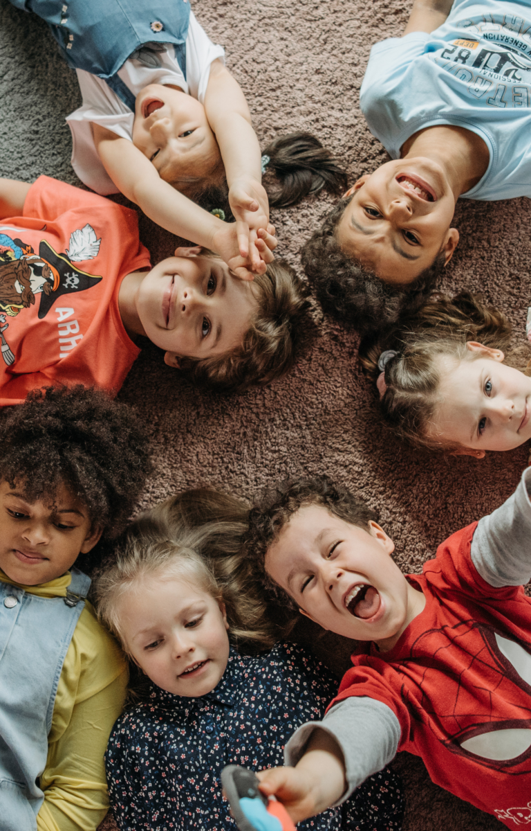 Fröhliches Kind beim Spielen im Wartebereich eines modernen Kinderambulatoriums – kindgerechte Umgebung und einfühlsame Betreuung stehen im Mittelpunkt.